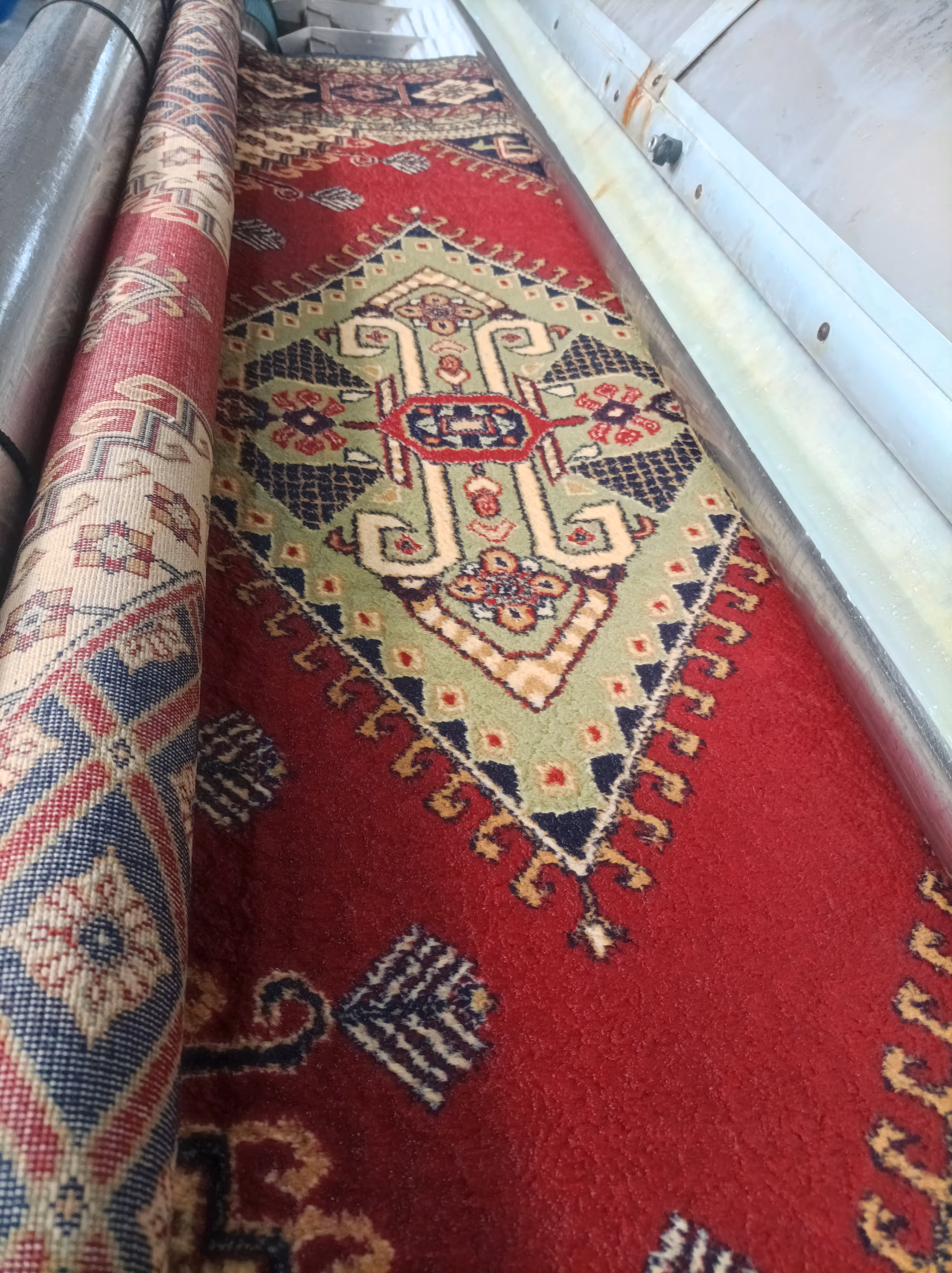 Dervişoğulları tesisinde yıkama makinesinde işlenen kırmızı desenli klasik halı
